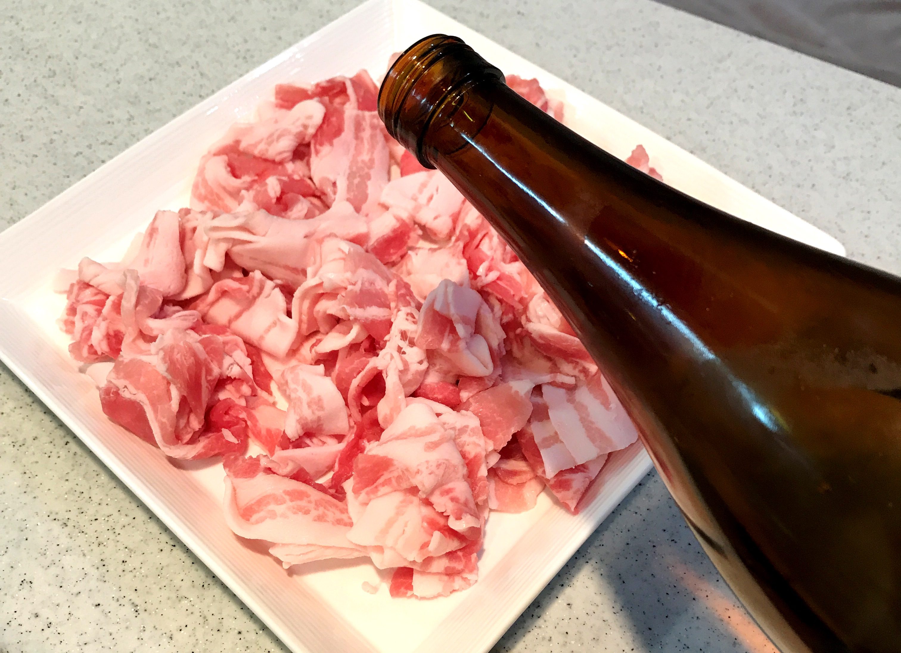 豚バラにお酒を振りかける
